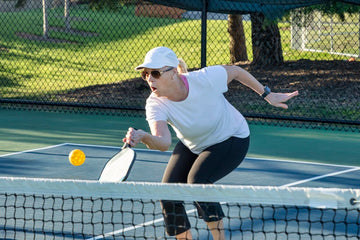 Senior players enjoying a game of pickleball on a sunny day.