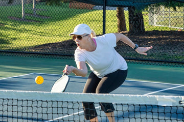 Senior players enjoying a game of pickleball on a sunny day.