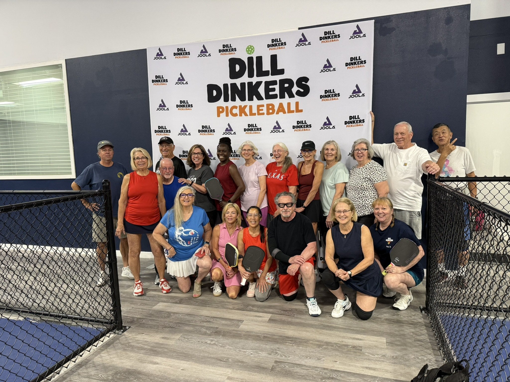 A large group of pickleball players gathered at an indoor clinic