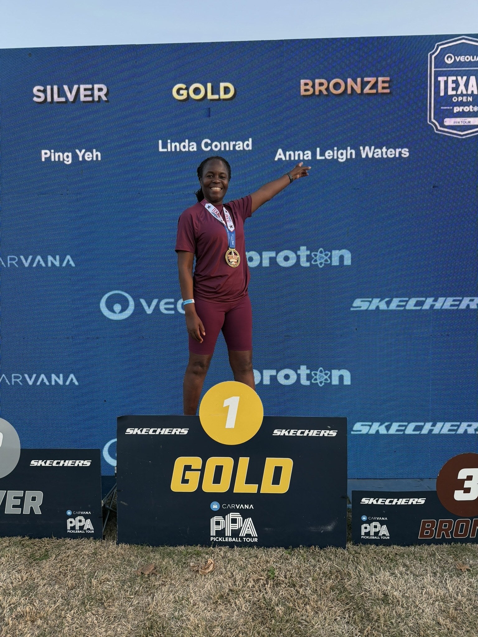 Linda Conrad standing on a professional pickleball tournament podium